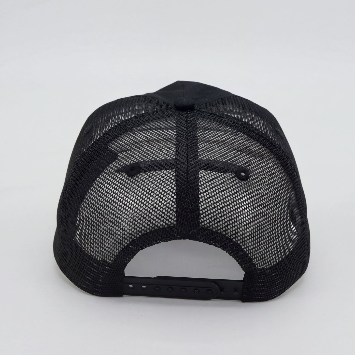 Back view of men’s black trucker cap with mesh panels and adjustable snapback closure