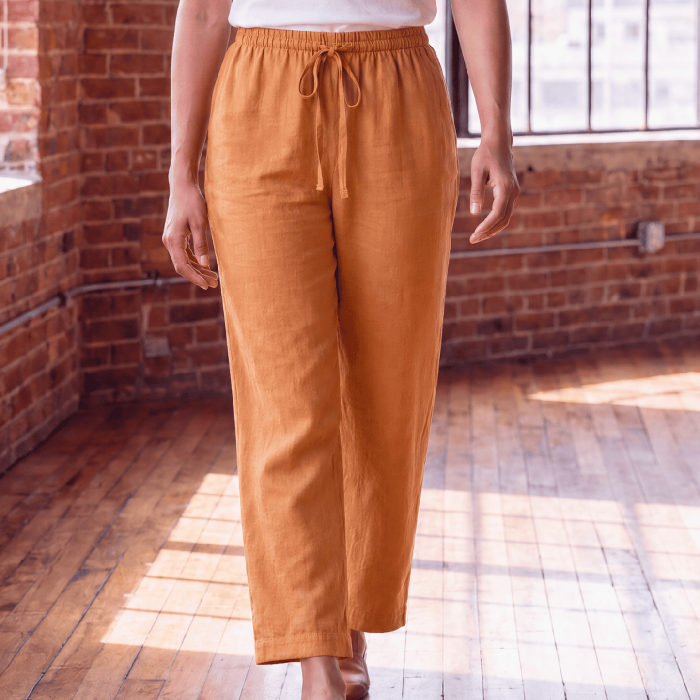 Close-up of women’s brown linen pants with drawstring waist and relaxed fit