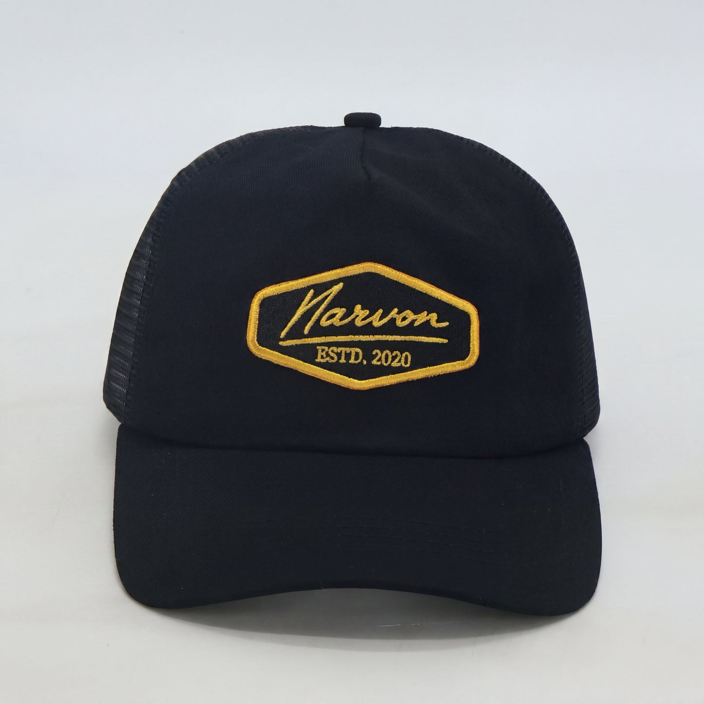 Front view of men’s black trucker cap with embroidered logo patch and curved brim