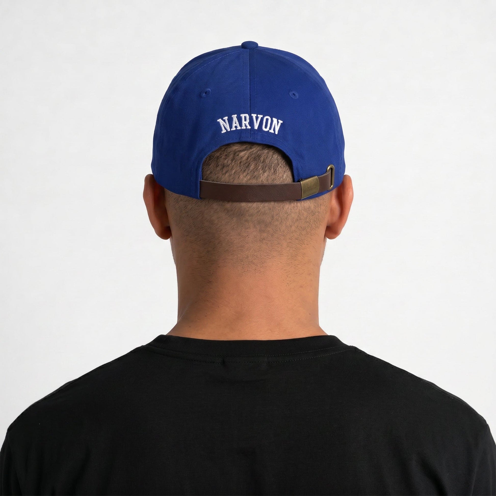 Back view of men’s blue dad cap worn on model showing adjustable leather strapback and embroidered detail
