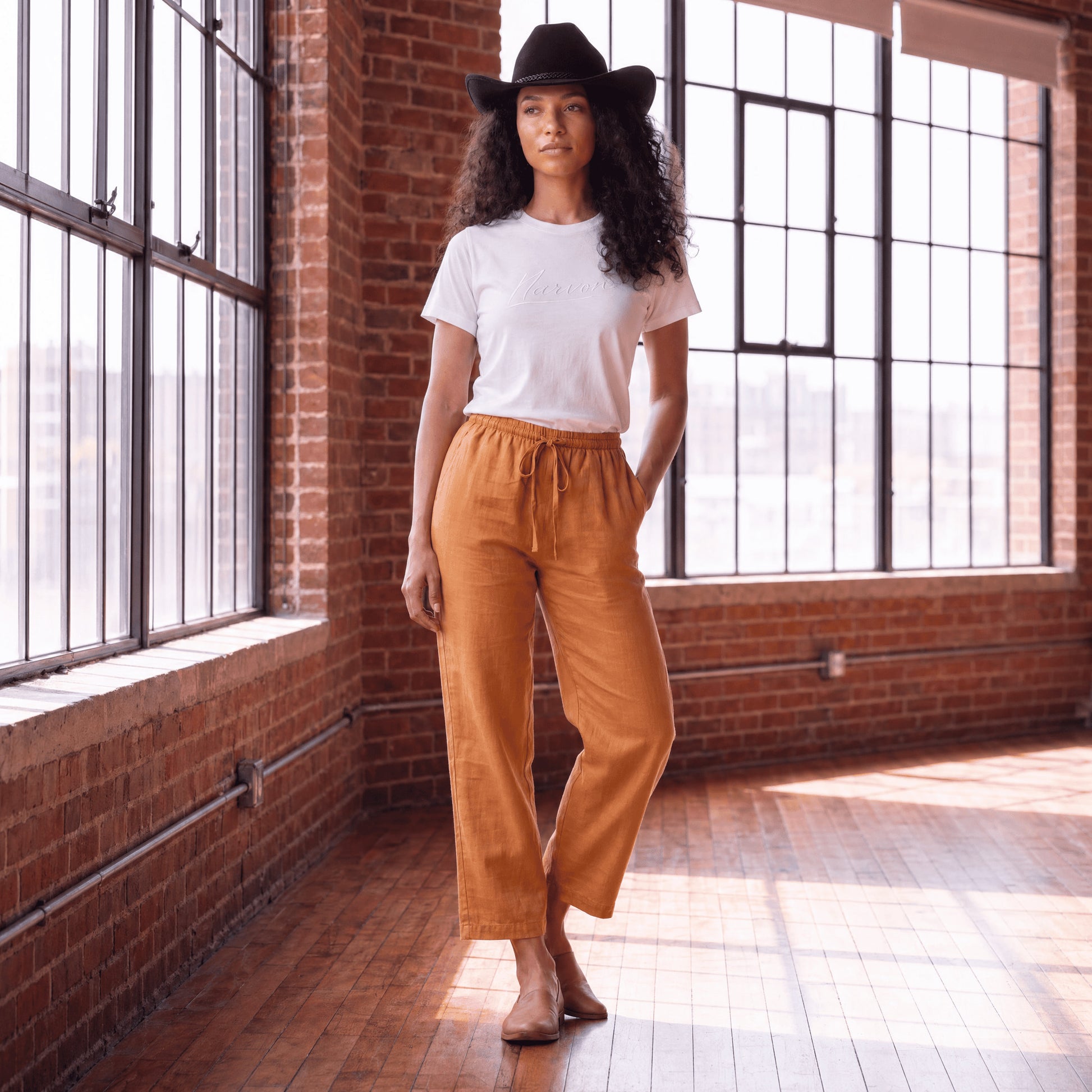 Woman wearing brown linen pants with relaxed fit and wide leg in a premium casual style